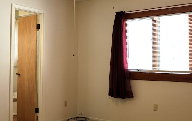 spare room with baseboards and a wealth of natural light