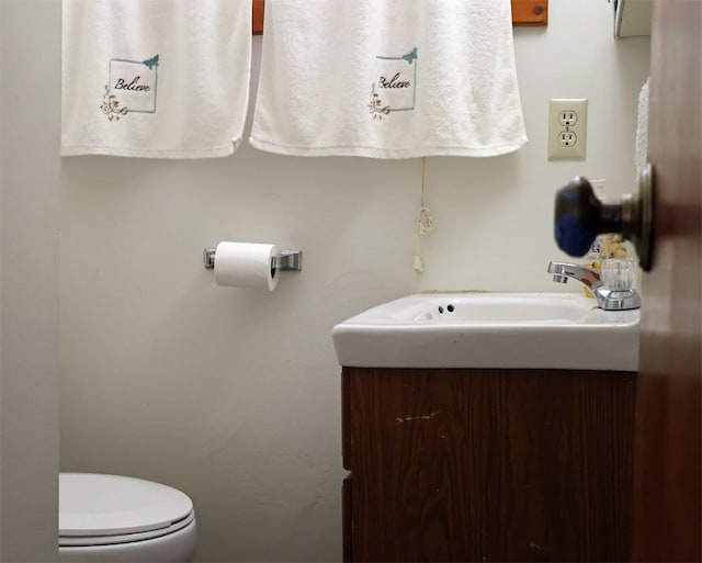 half bathroom with vanity and toilet