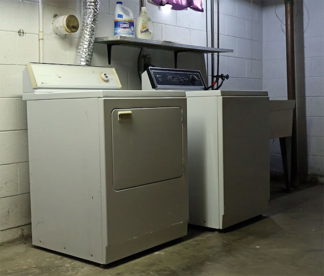 washroom featuring washer and dryer and concrete block wall