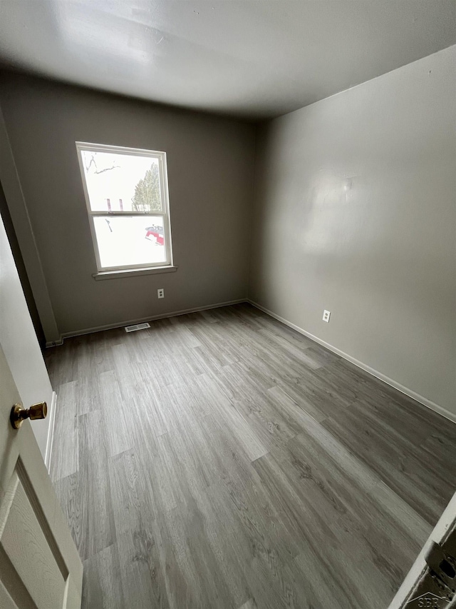 3704 Huntley St, Saginaw, MI 48601 - empty room featuring baseboards, wood finished floors, and visible vents