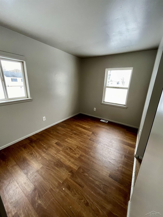 3704 Huntley St, Saginaw, MI 48601 - spare room featuring visible vents, dark wood finished floors, baseboards, and a healthy amount of sunlight