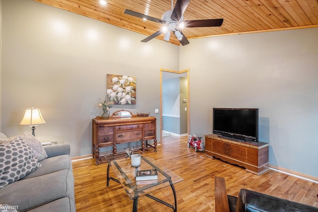 living room with a ceiling fan, baseboards, wood finished floors, a towering ceiling, and wood ceiling