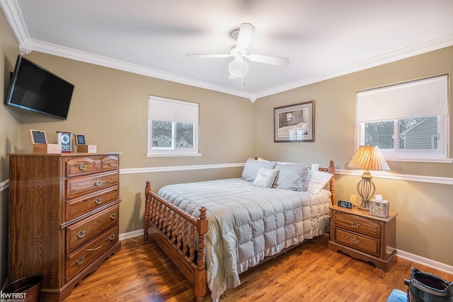 bedroom featuring crown molding, a ceiling fan, baseboards, and light wood finished floors