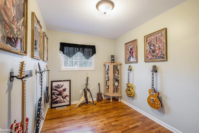 miscellaneous room featuring baseboards, visible vents, and wood finished floors