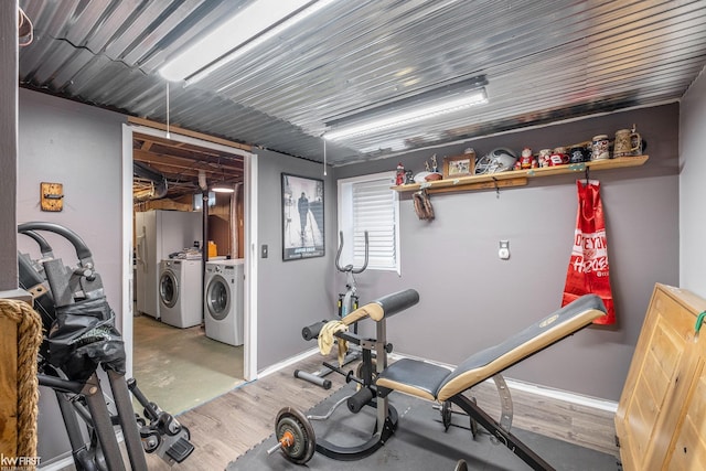 exercise area featuring baseboards and washing machine and clothes dryer