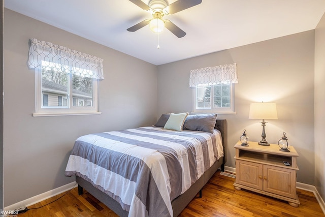 bedroom with baseboards, multiple windows, and light wood-style flooring
