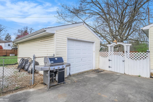 detached garage with fence, a gate, and driveway