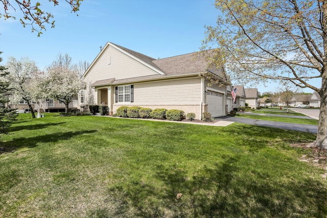 view of property exterior with a lawn, a shingled roof, a garage, and aphalt driveway