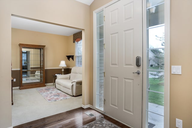 foyer featuring baseboards and wood finished floors
