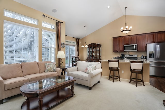 living area featuring an inviting chandelier, high vaulted ceiling, and light carpet