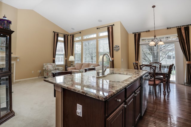 kitchen featuring dark brown cabinets, vaulted ceiling, a wealth of natural light, and a sink