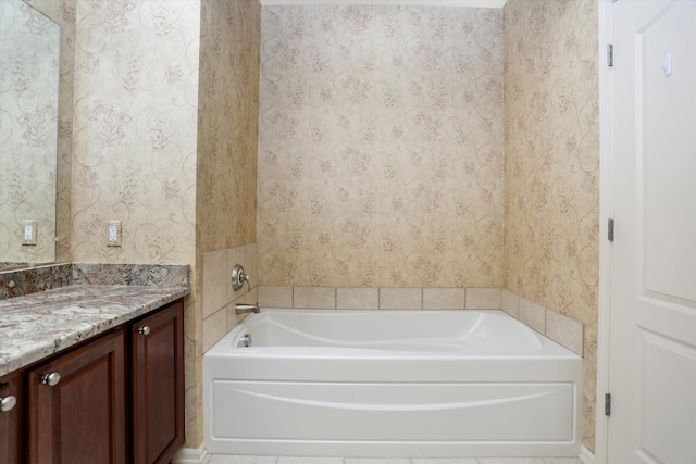 bathroom featuring vanity, a garden tub, and wallpapered walls