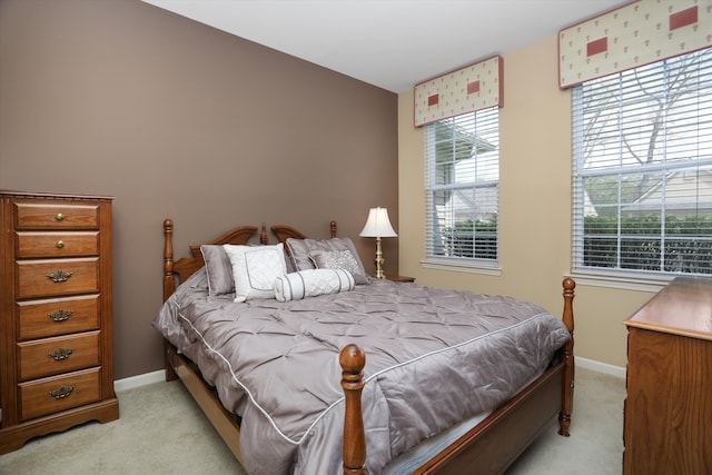 bedroom featuring baseboards and light colored carpet