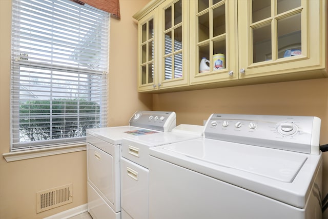 laundry area featuring visible vents, washer and clothes dryer, and cabinet space