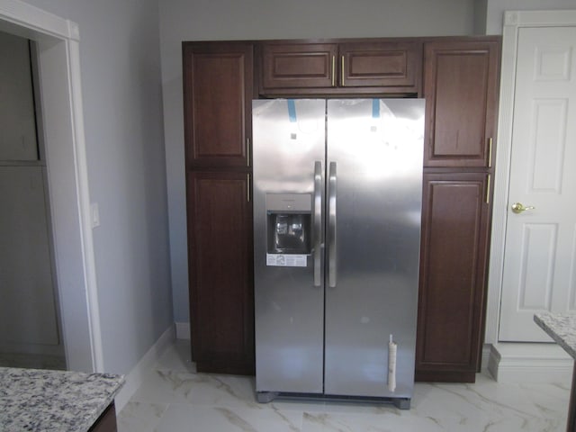 kitchen featuring light stone counters, marble finish floor, and stainless steel fridge with ice dispenser