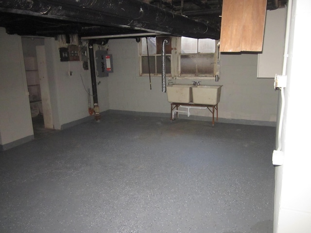 unfinished basement featuring a sink, baseboards, and electric panel