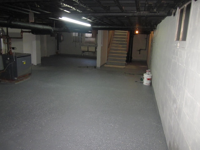 finished below grade area featuring concrete block wall and stairway