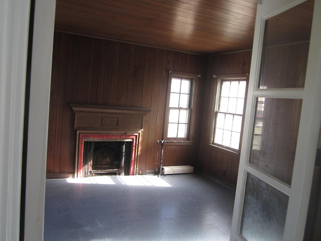 unfurnished living room with wooden walls, wooden ceiling, and a fireplace