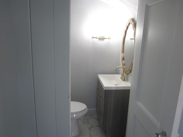 bathroom featuring vanity, toilet, and marble finish floor