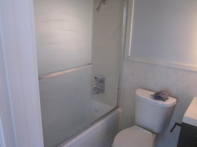 bathroom with vanity, toilet, and shower / bath combination with glass door