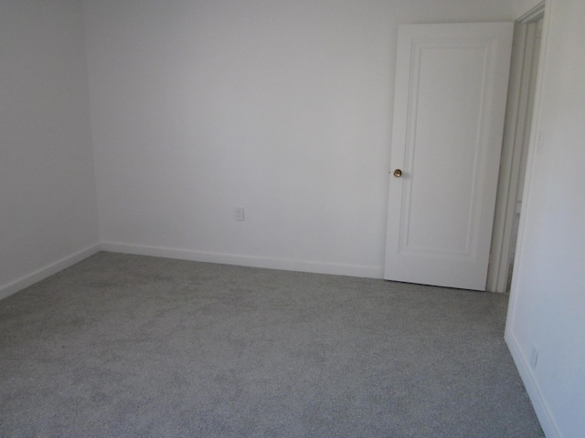 carpeted empty room with baseboards