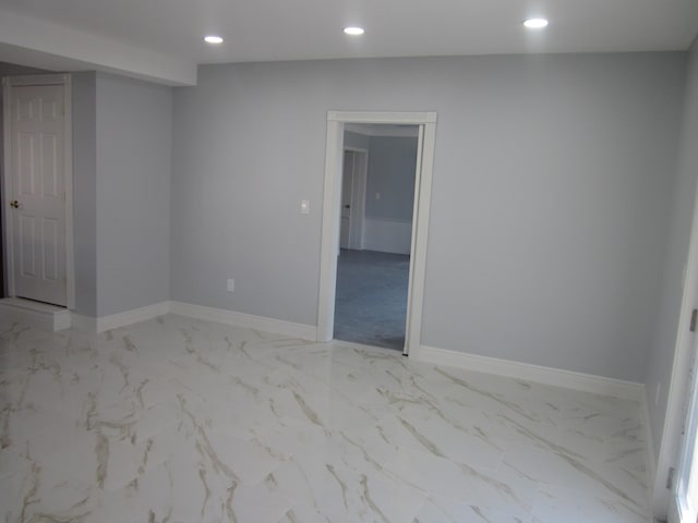 spare room featuring recessed lighting, baseboards, and marble finish floor