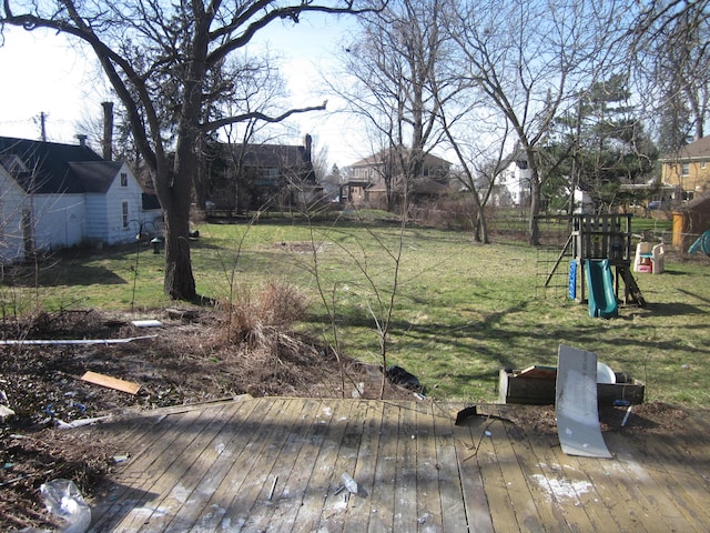 view of yard with a playground, fence, and a wooden deck