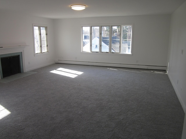 unfurnished living room with carpet floors, a baseboard radiator, baseboards, and a fireplace with flush hearth