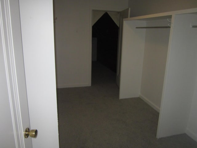 corridor featuring baseboards and carpet