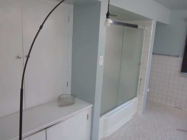 bathroom featuring bath / shower combo with glass door, a ceiling fan, and tile patterned floors