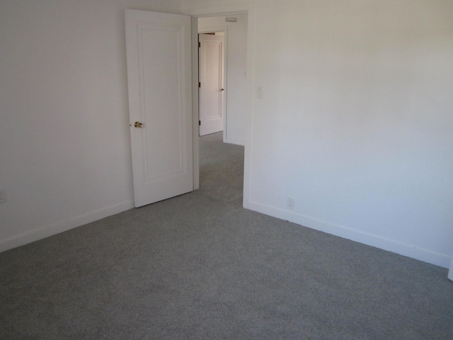carpeted spare room featuring baseboards