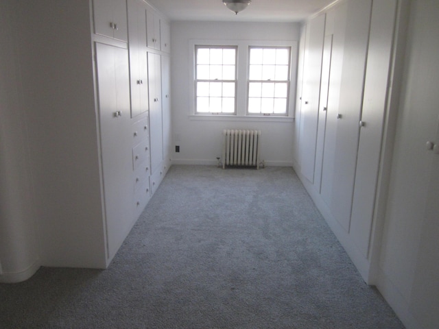 unfurnished bedroom featuring light colored carpet and radiator heating unit