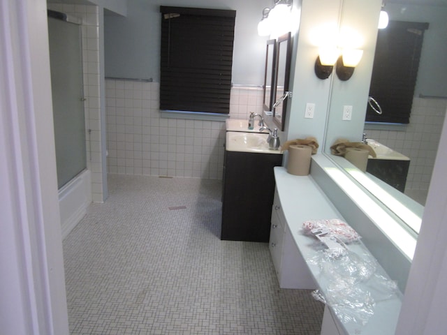 full bathroom with vanity, walk in shower, and tile walls