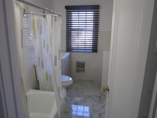 full bath with toilet, tile walls, and marble finish floor