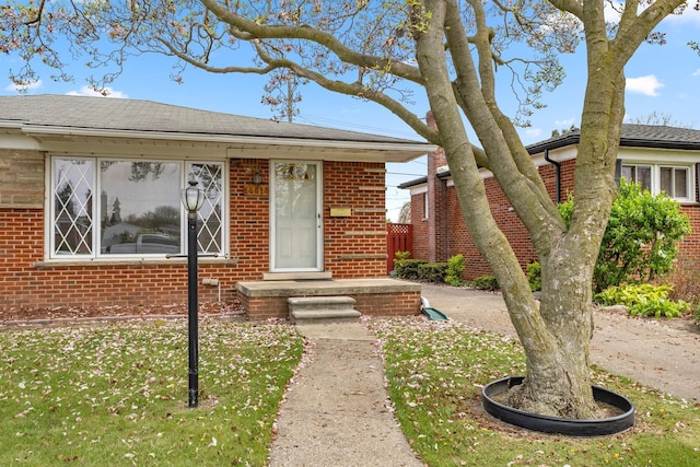 bungalow-style house with brick siding and a shingled roof