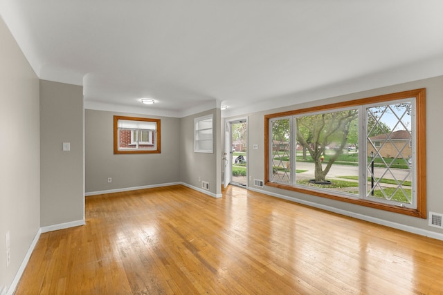 unfurnished living room with baseboards, visible vents, and light wood finished floors