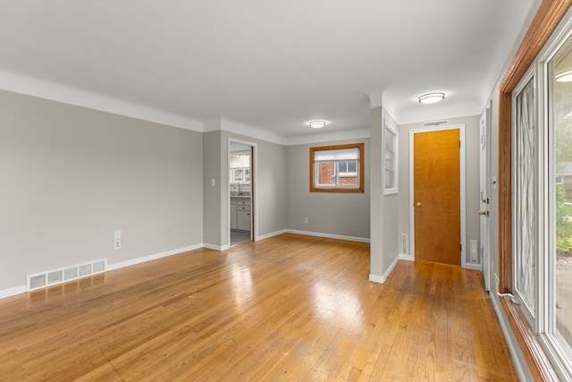 foyer entrance featuring baseboards, visible vents, and light wood finished floors