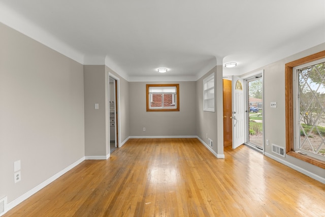 spare room featuring baseboards, light wood finished floors, and visible vents