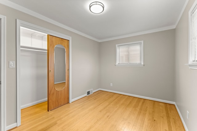 unfurnished bedroom with baseboards, visible vents, ornamental molding, and light wood finished floors