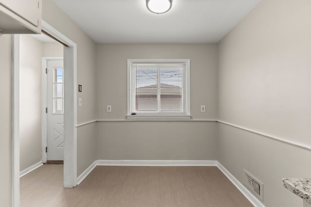 spare room with visible vents, baseboards, and plenty of natural light