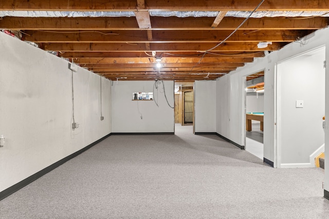 unfinished basement featuring pool table, baseboards, and light carpet