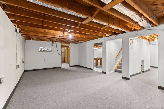 finished below grade area with carpet floors, baseboards, and stairway