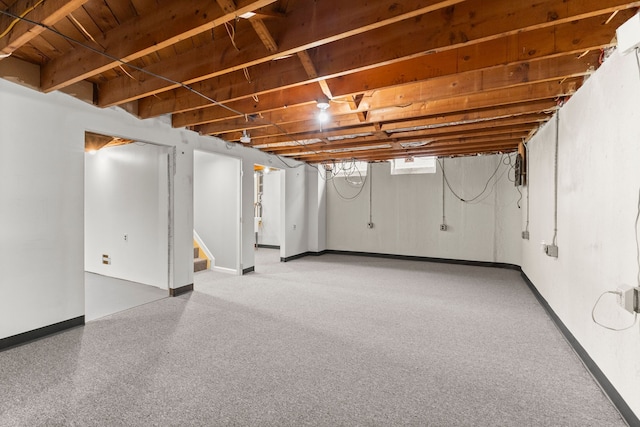 below grade area featuring baseboards and stairs