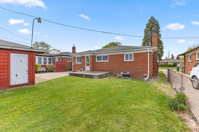 back of property with fence private yard, brick siding, a yard, and a chimney