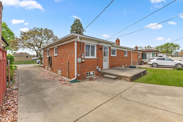 exterior space featuring a yard, brick siding, and a chimney