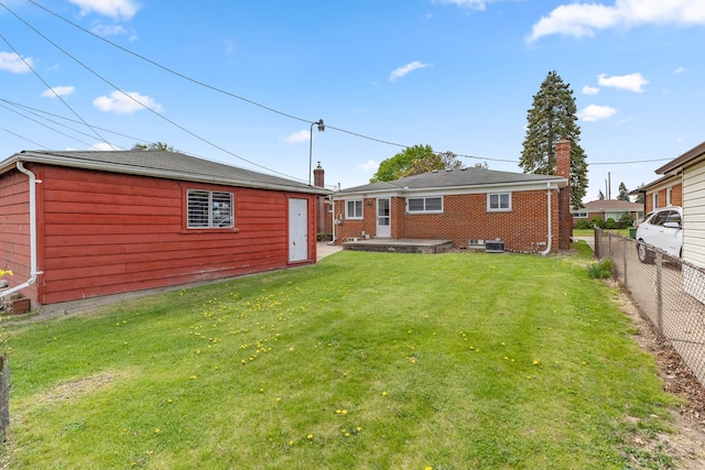 rear view of property featuring a lawn, fence, a chimney, and a patio area