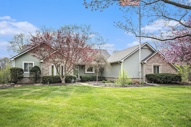 view of front facade with a front yard and brick siding