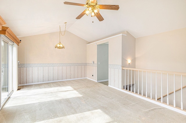 carpeted spare room with ceiling fan and vaulted ceiling