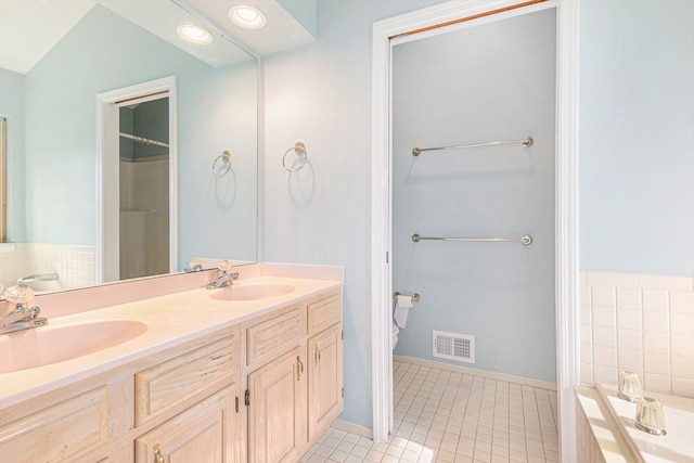 bathroom featuring visible vents, a sink, a bathtub, and tile patterned floors