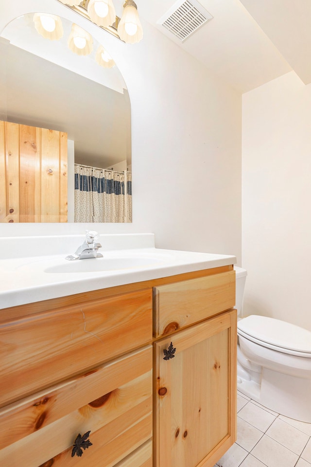 bathroom with toilet, tile patterned floors, visible vents, and vanity